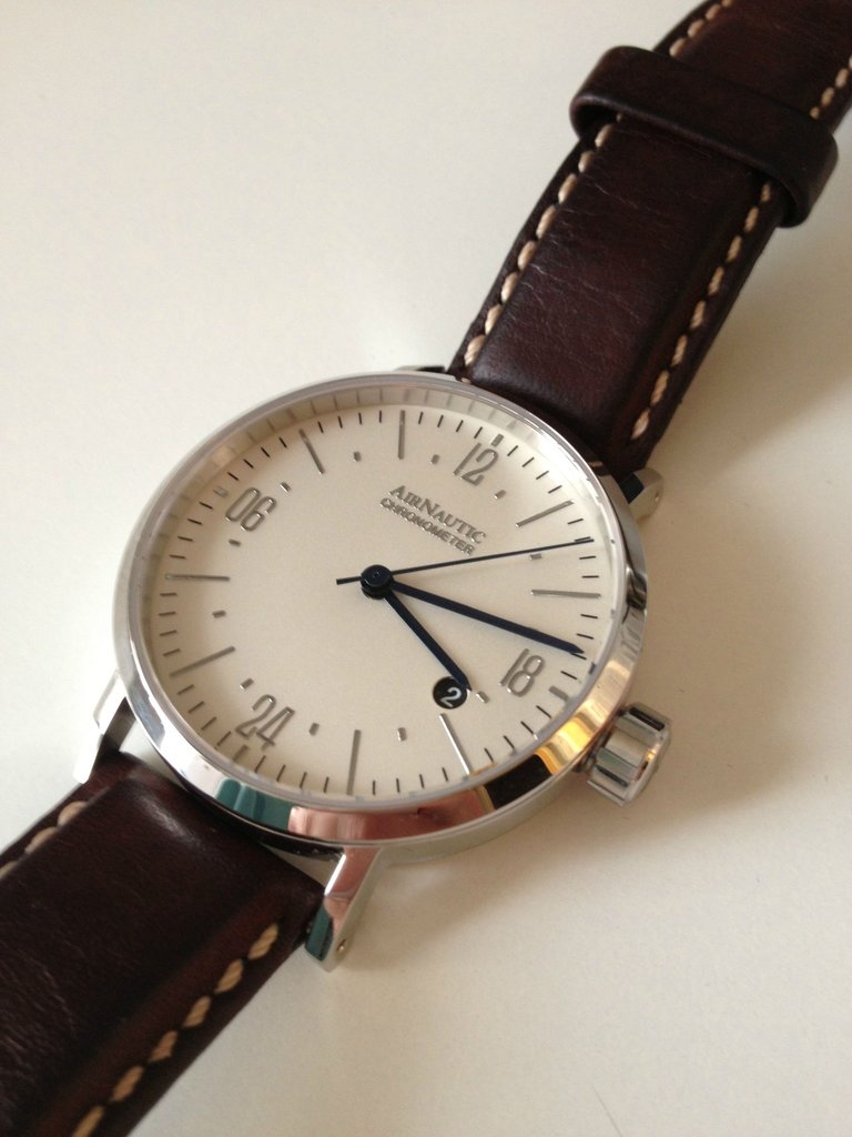 I think brown leather strap fits much better. The beige stitching looks great with the cream dial!
